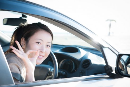 笑顔で車に乗る女性