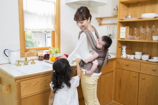 赤ちゃんをおんぶして家事をするお母さん