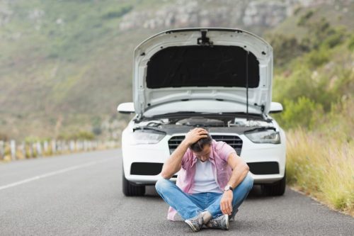 車が故障して困り果てる男性