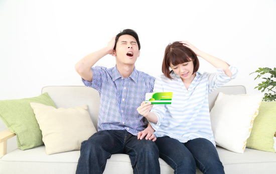 通帳を見て残念がる夫婦